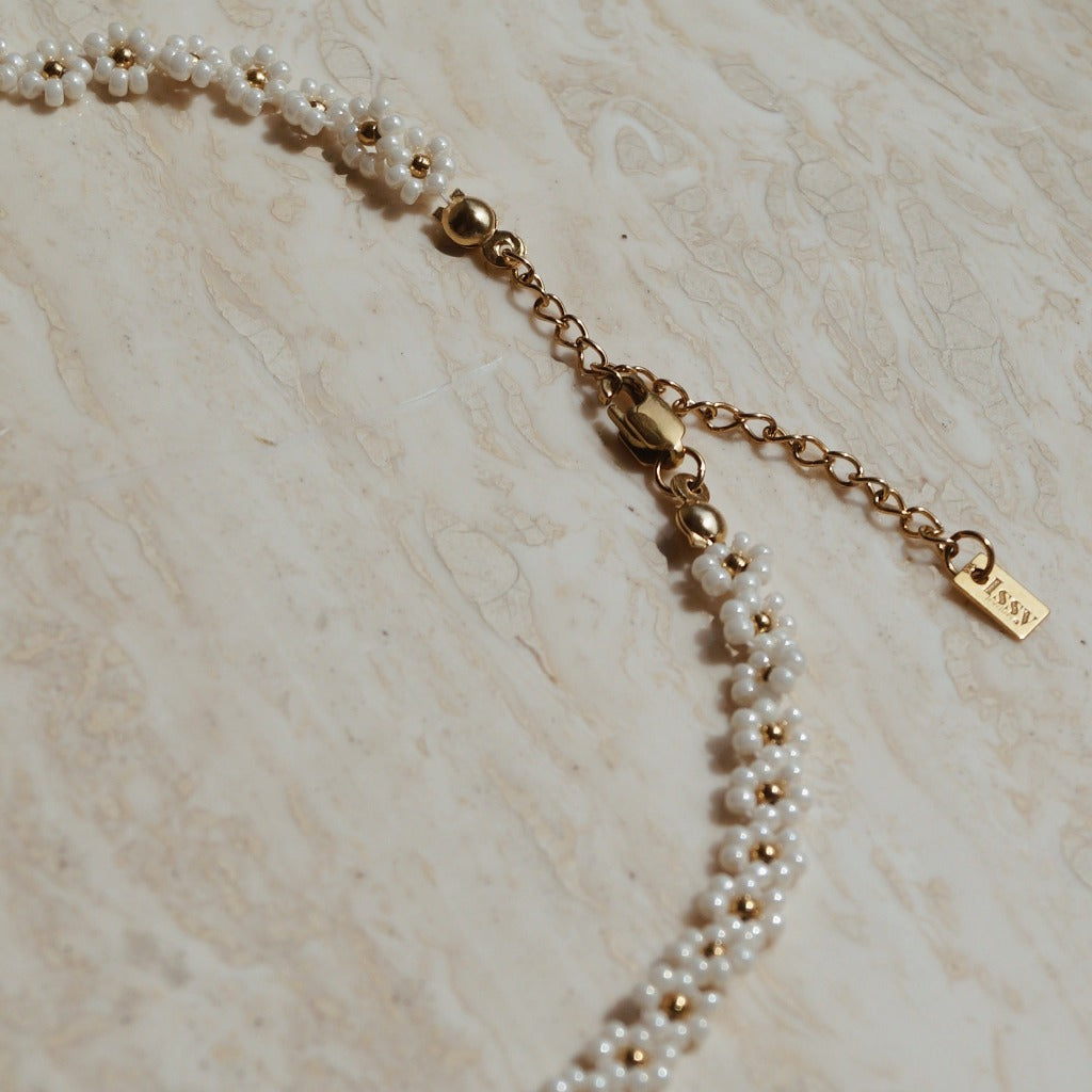 Verfijnde ketting in wit goud met bloemetjes, Gouden ketting met witte bloemetjes, Bloemige halsaccessoire in wit goud, Luxe bloemen ketting met gouden accenten, Stijlvolle witte gouden bloemen ketting, Ketting met subtiel bloemdesign, Gouden ketting met elegante bloemetjes