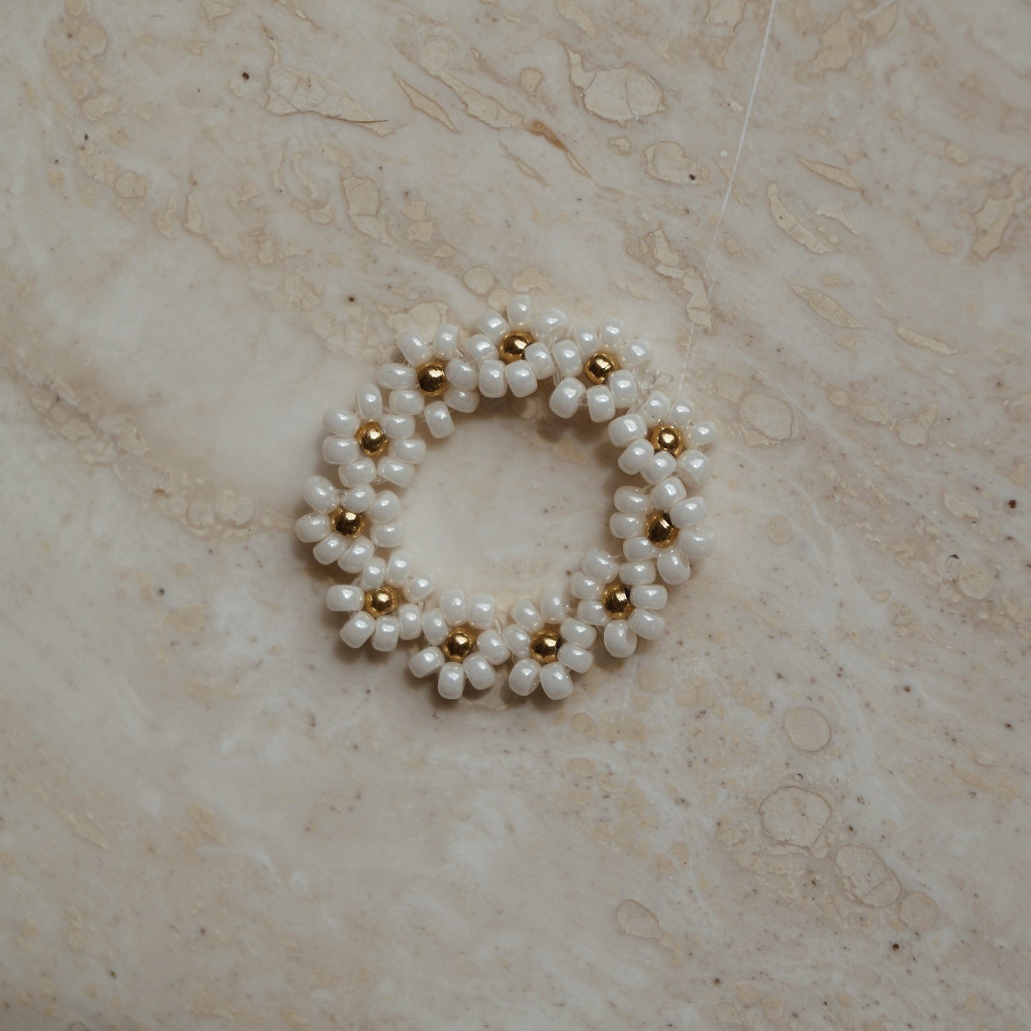 Elastiek ring bloemetjes wit goud, Wit gouden elastische ring met bloemetjes, Bloemmotief elastische ring in wit goud, Elastische ring met witte gouden bloemetjes, Wit gouden bloemen elastische ring, Bloemenontwerp elastiek ring in wit goud, Chique wit gouden elastiek ring met bloemetjes, Verstelbare ring met bloemen in wit goud, Wit gouden elastische ring met subtiele bloemetjes, Elastische bloemenring in wit goud