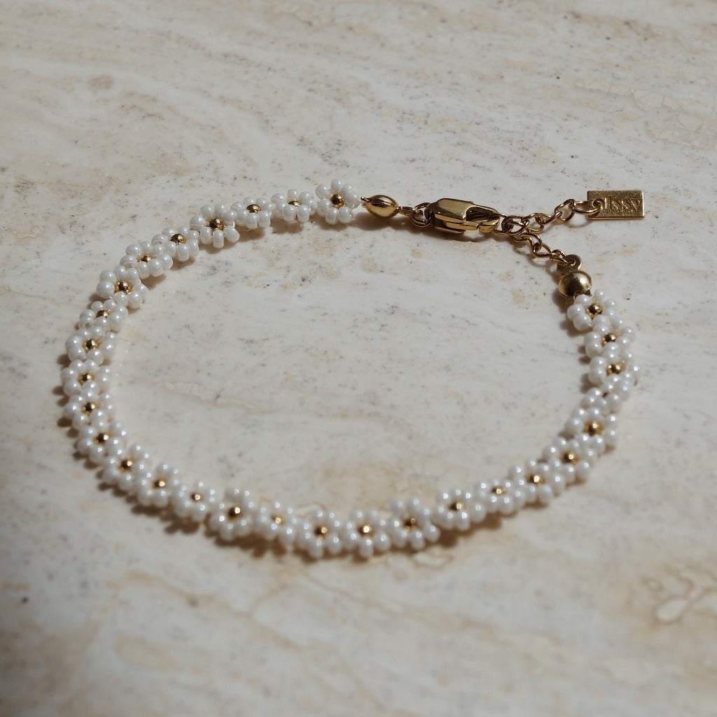 Wit gouden bloemetjes armband, Goudkleurige witte bloemenarmband, Armband met bloemmotief, Elegante witte gouden armband met bloemetjes, Bloemenmotief polsjuweel, Chique gouden armband met bloemen, Verfijnde armband in wit goud met bloemetjes, Gouden armband met witte bloemetjes