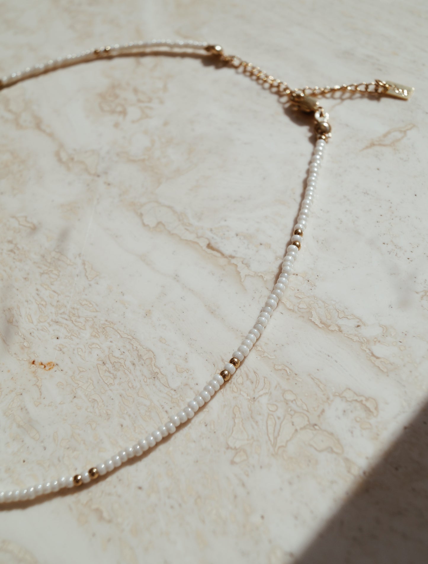 Fijne gouden details witte ketting, Gouden accenten op subtiele witte ketting