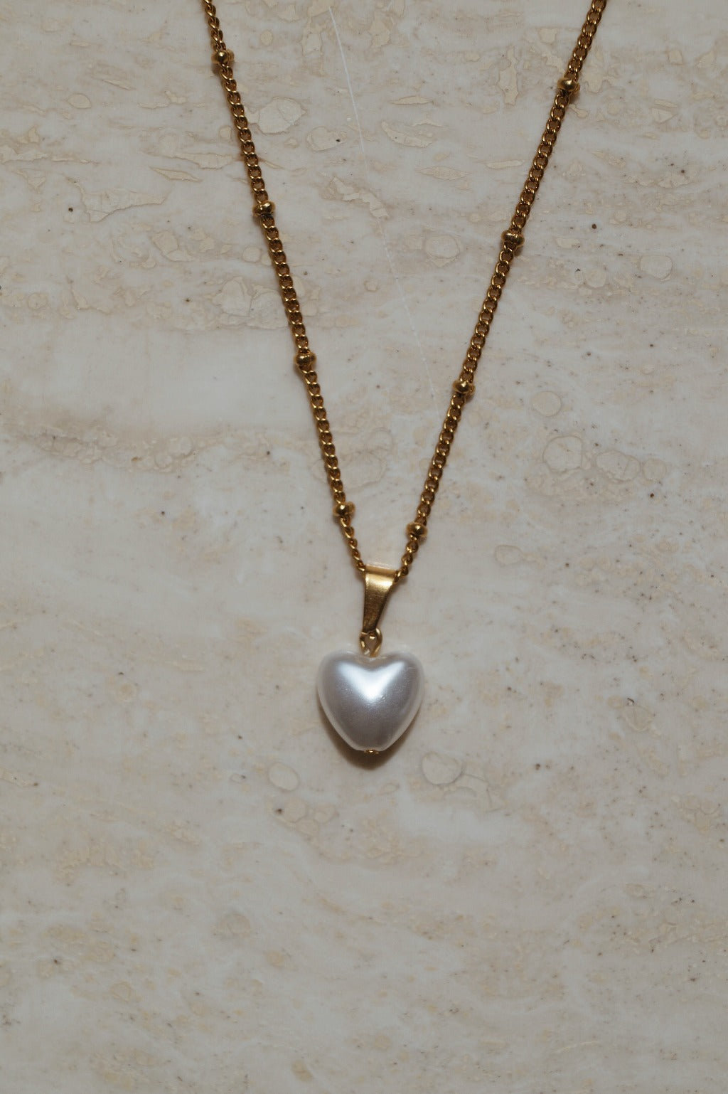 Gouden liefdeshart met parelhanger, Gouden ketting met hartvormige parelhanger, Parelhart sieraad met gouden ketting, Gouden parelhanger in hartvorm met ketting, Parelhanger en gouden hart ketting