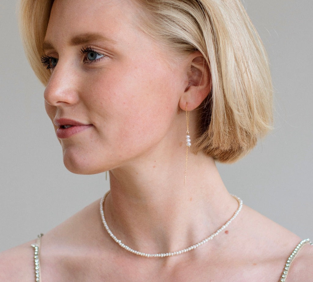 Hoogwaardige parel ketting. Gouden oorbellen met parels. Bruidssieraad