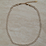 Wit gouden bloemetjes ketting, Delicate bloemen ketting, Goudkleurige witte bloemen halsketting, Ketting met bloemmotief, Elegante witte gouden ketting met bloemetjes, Bloemenmotief halsjuweel, Chique gouden ketting met bloemen