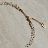 Verfijnde ketting in wit goud met bloemetjes, Gouden ketting met witte bloemetjes, Bloemige halsaccessoire in wit goud, Luxe bloemen ketting met gouden accenten, Stijlvolle witte gouden bloemen ketting, Ketting met subtiel bloemdesign, Gouden ketting met elegante bloemetjes