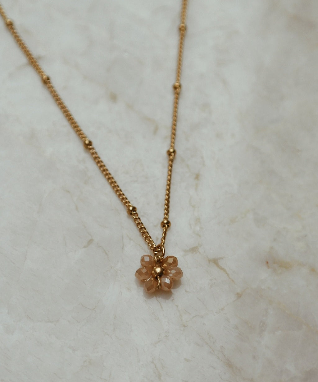 Gouden ketting met bloem in de kleur champagne.