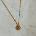 Gouden ketting met bloem in de kleur champagne.