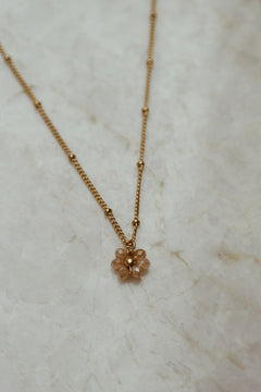 Gouden ketting met bloem in de kleur champagne.