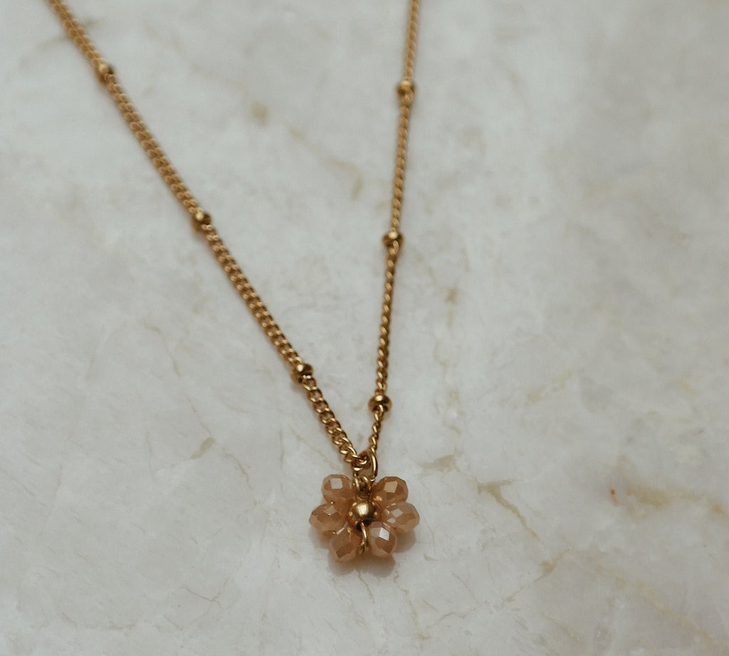 Gouden ketting met bloem in de kleur champagne.