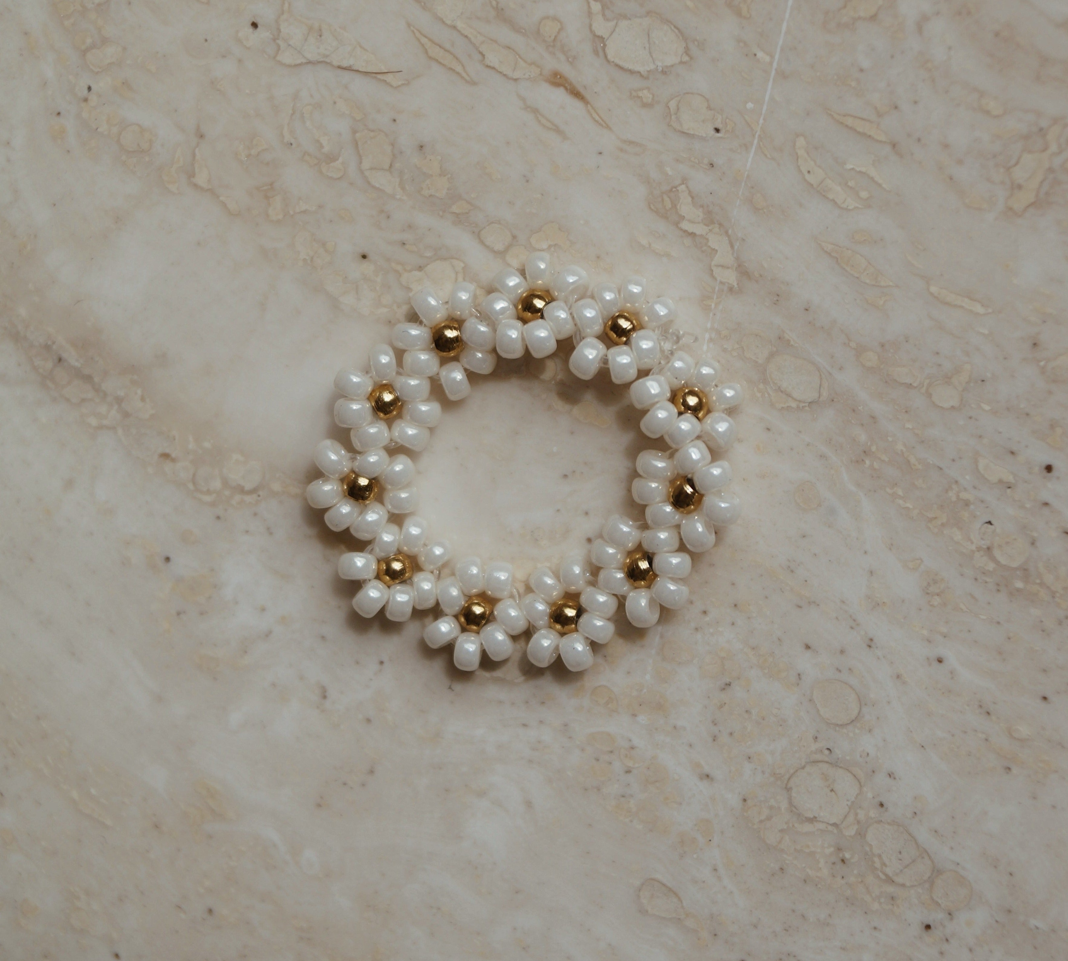 Elastiek ring bloemetjes wit goud, Wit gouden elastische ring met bloemetjes, Bloemmotief elastische ring in wit goud, Elastische ring met witte gouden bloemetjes, Wit gouden bloemen elastische ring, Bloemenontwerp elastiek ring in wit goud, Chique wit gouden elastiek ring met bloemetjes, Verstelbare ring met bloemen in wit goud, Wit gouden elastische ring met subtiele bloemetjes, Elastische bloemenring in wit goud