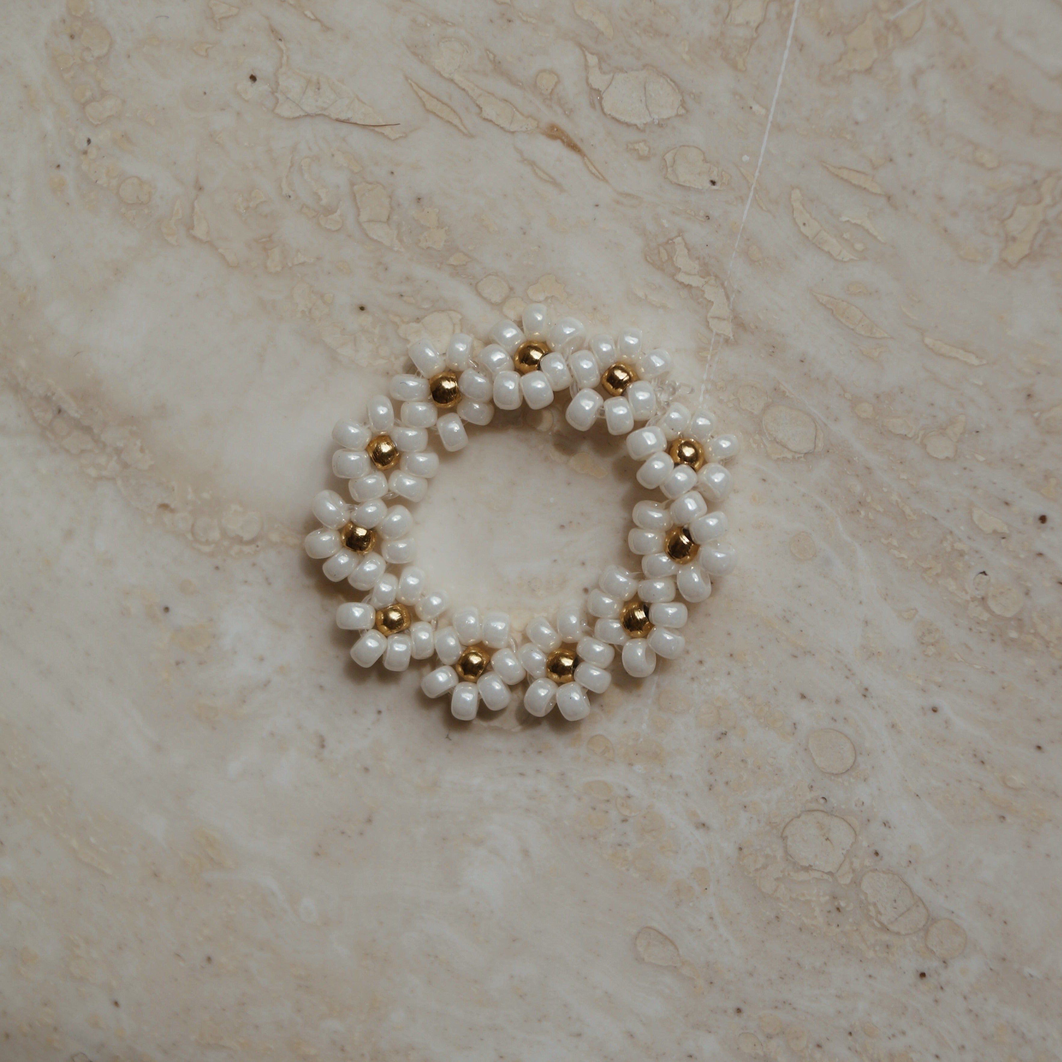 Elastiek ring bloemetjes wit goud, Wit gouden elastische ring met bloemetjes, Bloemmotief elastische ring in wit goud, Elastische ring met witte gouden bloemetjes, Wit gouden bloemen elastische ring, Bloemenontwerp elastiek ring in wit goud, Chique wit gouden elastiek ring met bloemetjes, Verstelbare ring met bloemen in wit goud, Wit gouden elastische ring met subtiele bloemetjes, Elastische bloemenring in wit goud