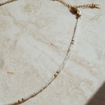 Fijne gouden details witte ketting, Gouden accenten op subtiele witte ketting