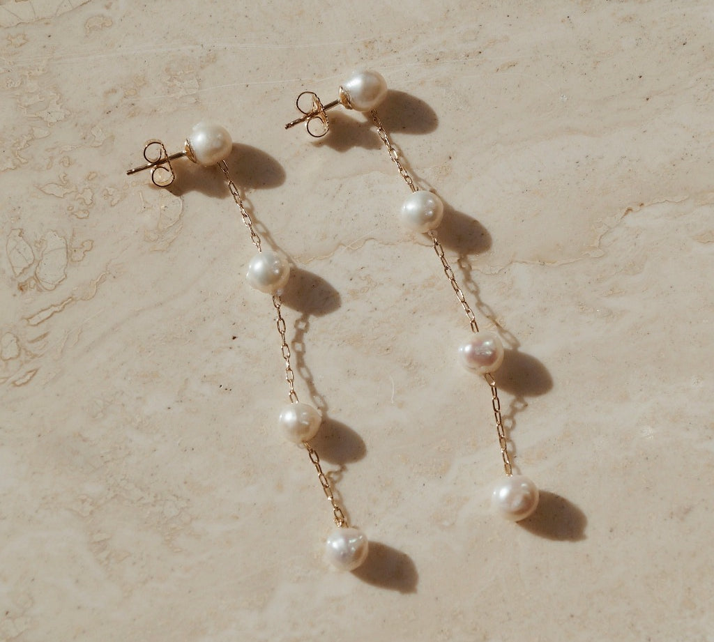 Gouden gold filled oorbellen met vier grotere parels met daartussen een subtiele gouden chain. 