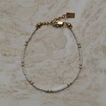 Armbandje goud en wit design, Witte kralen armband met gouden accenten