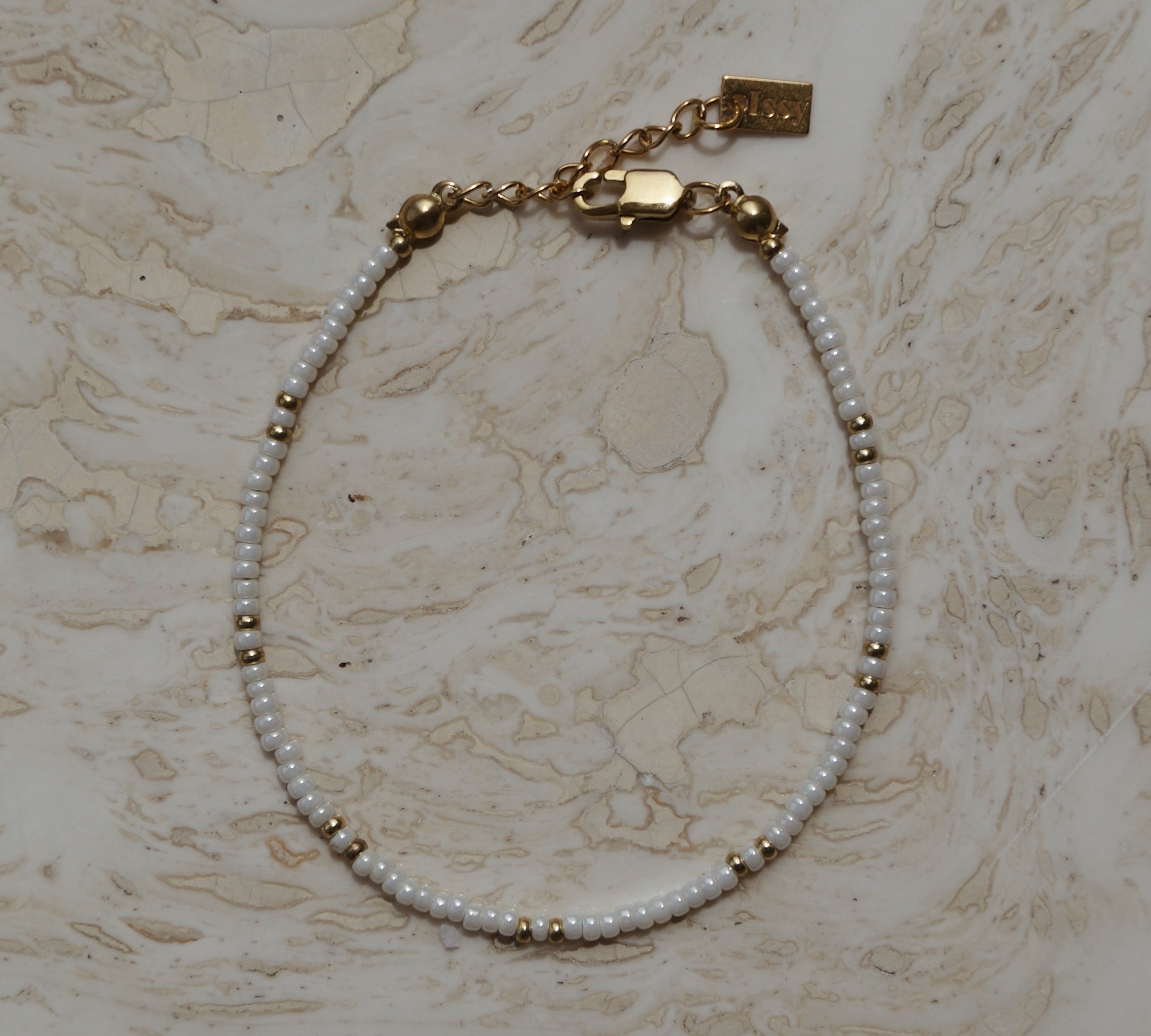 Armbandje goud en wit design, Witte kralen armband met gouden accenten