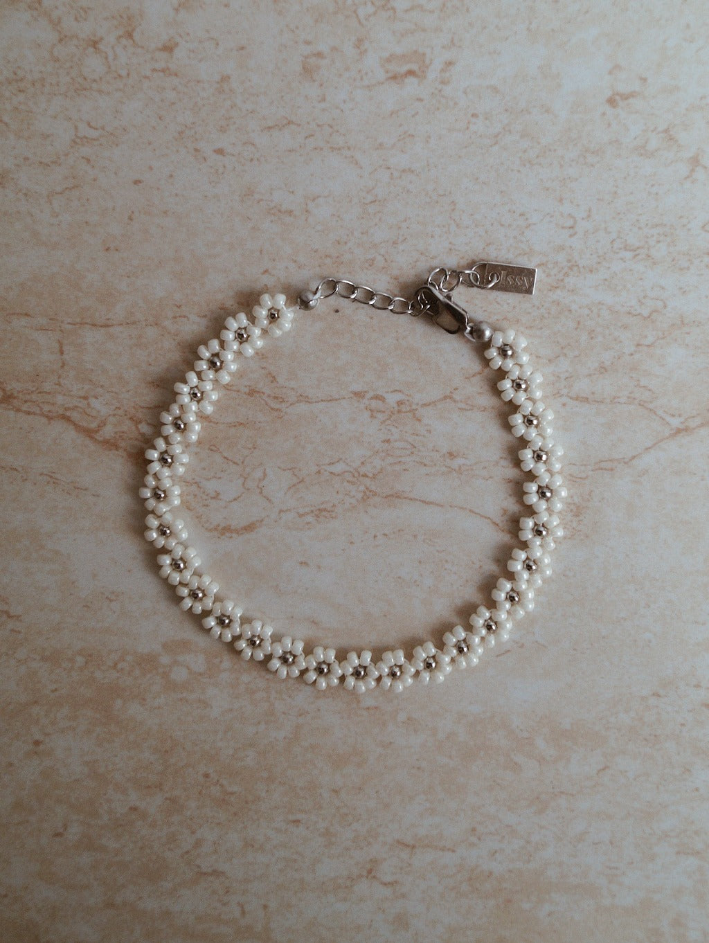 Luxe bloemen armband met gouden accenten, Stijlvolle witte gouden bloemen armband, Gouden armband met elegante bloemetjes, Wit goud armband met bloemaccent, Chique armband met witte gouden bloemen, Armband met verfijnde bloemmotieven