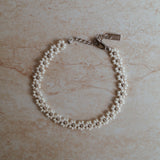 Luxe bloemen armband met gouden accenten, Stijlvolle witte gouden bloemen armband, Gouden armband met elegante bloemetjes, Wit goud armband met bloemaccent, Chique armband met witte gouden bloemen, Armband met verfijnde bloemmotieven