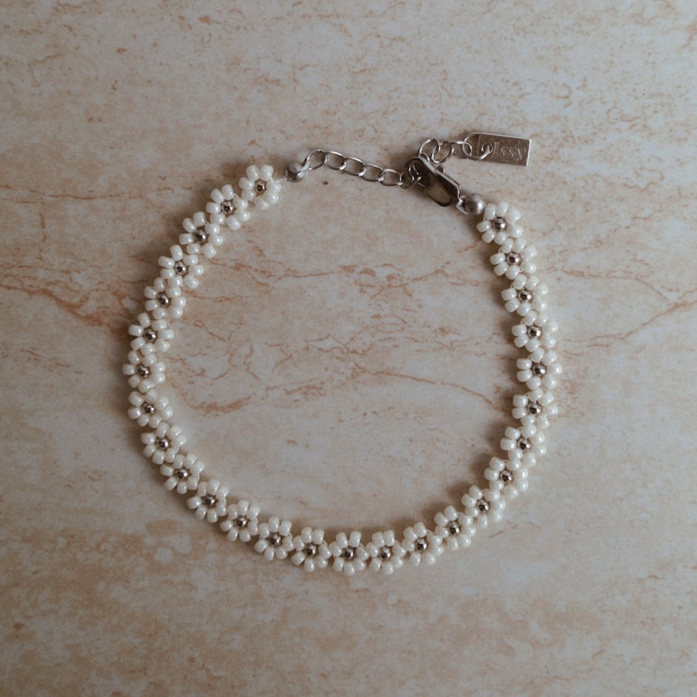 Luxe bloemen armband met gouden accenten, Stijlvolle witte gouden bloemen armband, Gouden armband met elegante bloemetjes, Wit goud armband met bloemaccent, Chique armband met witte gouden bloemen, Armband met verfijnde bloemmotieven